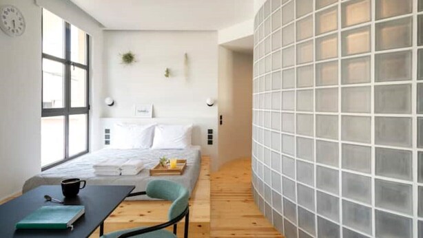 A modern bedroom with a bed, bedside tables, a desk with a chair, and a large window. - Hoppersgr- Amazing apt in the heart of Athens - 4 (Athina)