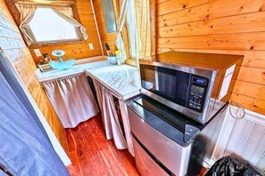 A compact kitchen with a microwave, oven, and a small countertop.