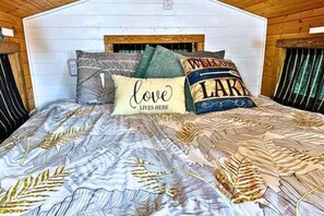 A bed with a patterned bedspread and pillows with text. - 2  Lakefront, Comfortable Bed, Great Fishing (Eastland)