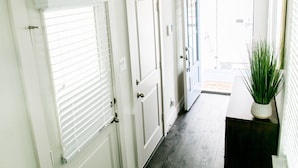 A hallway with white doors, a potted plant, and a deer skull decoration. - Mid-Century Modern Home is 10 minutes from Downtown Houston (Houston)