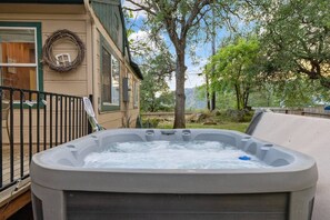 A hot tub in a backyard with a wooden deck, a metal railing, and a house with a wreath on the wall. - 3 Bedrooms Hot Tub, 4mi from Sequoia, Games (Three Rivers)