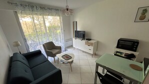 Un salon moderne comprenant un canapé, une table à manger, un téléviseur et un four à micro-ondes.