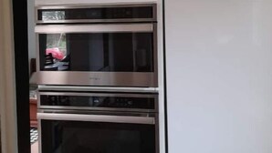 Una cocina con horno empotrado y un refrigerador blanco.