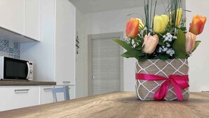 A wooden table with a decorative flower arrangement in a burlap-wrapped pot with a pink ribbon. - Holiday apartment with balcony and air conditioning (Rosolina Mare)