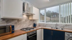 Una cucina moderna con piano cottura a gas, forno, microonde ed elettrodomestici integrati.