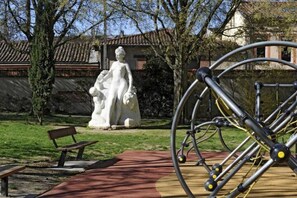 Un parc avec une statue, un vélo et un banc.