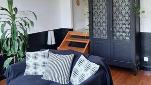 A living room with a sofa, a cabinet with decorative glass panels, and a hanging light fixture.