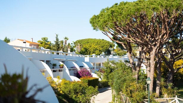 A modern hotel with white architecture, a large tree, and a clear sky. - Cozy 2 BDR W/Balcony in Vale do Lobo by LovelyStay (Almansil)