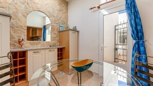 A modern bathroom with a stone wall, a glass table with a wooden bowl, and a blue curtain. - Cozy 2 BDR W/Balcony in Vale do Lobo by LovelyStay (Almansil)