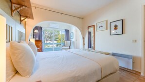 A spacious bedroom with a large bed, a view through an arched doorway, and a radiator on the wall. - Cozy 2 BDR W/Balcony in Vale do Lobo by LovelyStay (Almansil)