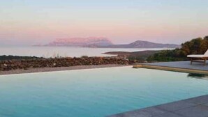 A pool with a view of a distant island and rocky shoreline. - Pittulongu Olbia Residence A Domo Mea Retreat (Pittulongu)