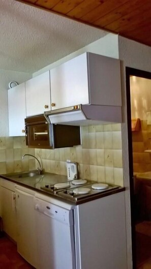 Kitchen area with microwave oven, sink, and tiled backsplash.