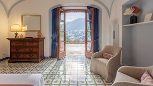 Ein Hotelzimmer mit Blick auf Stadt und Berge durch einen offenen Durchgang.