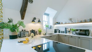 Una cocina moderna con una isla central, electrodomésticos integrados y un tragaluz.