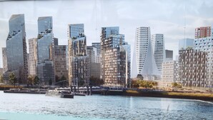 A modern cityscape with high-rise buildings along a waterfront. - Stunning 1-bed Apartment in London With River View (London)