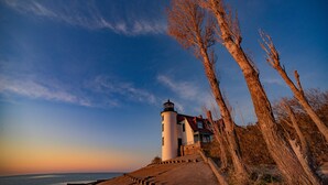 A lighthouse with a white exterior and a red roof, situated on a concrete embankment beside a body of water. - 2 King BDR with a Loft Golf Course 5569 (Williamsburg)