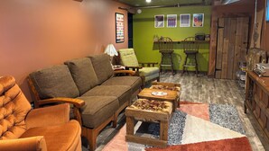Ein gemütliches Wohnzimmer mit einer Couch, Sesseln, einem Couchtisch und einem Essbereich mit Stühlen.