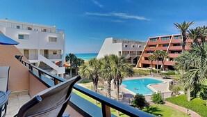 Et hotel med flere bygninger, en swimmingpool og udsigt til havet.