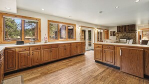 Una cocina amplia con armarios de madera, ventanas grandes y vistas al exterior.