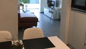 A modern kitchen with a built-in oven and a dining area with a table and chairs. - Ferienwohnung auf der Höri, Terrasse und Garten, 8 Minuten Fußweg zum Bodensee (Gaienhofen)