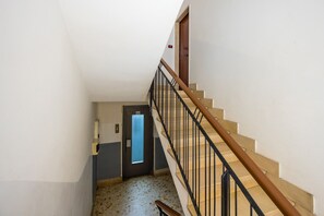 Stairs lead to an elevator with a door featuring a frosted glass panel.