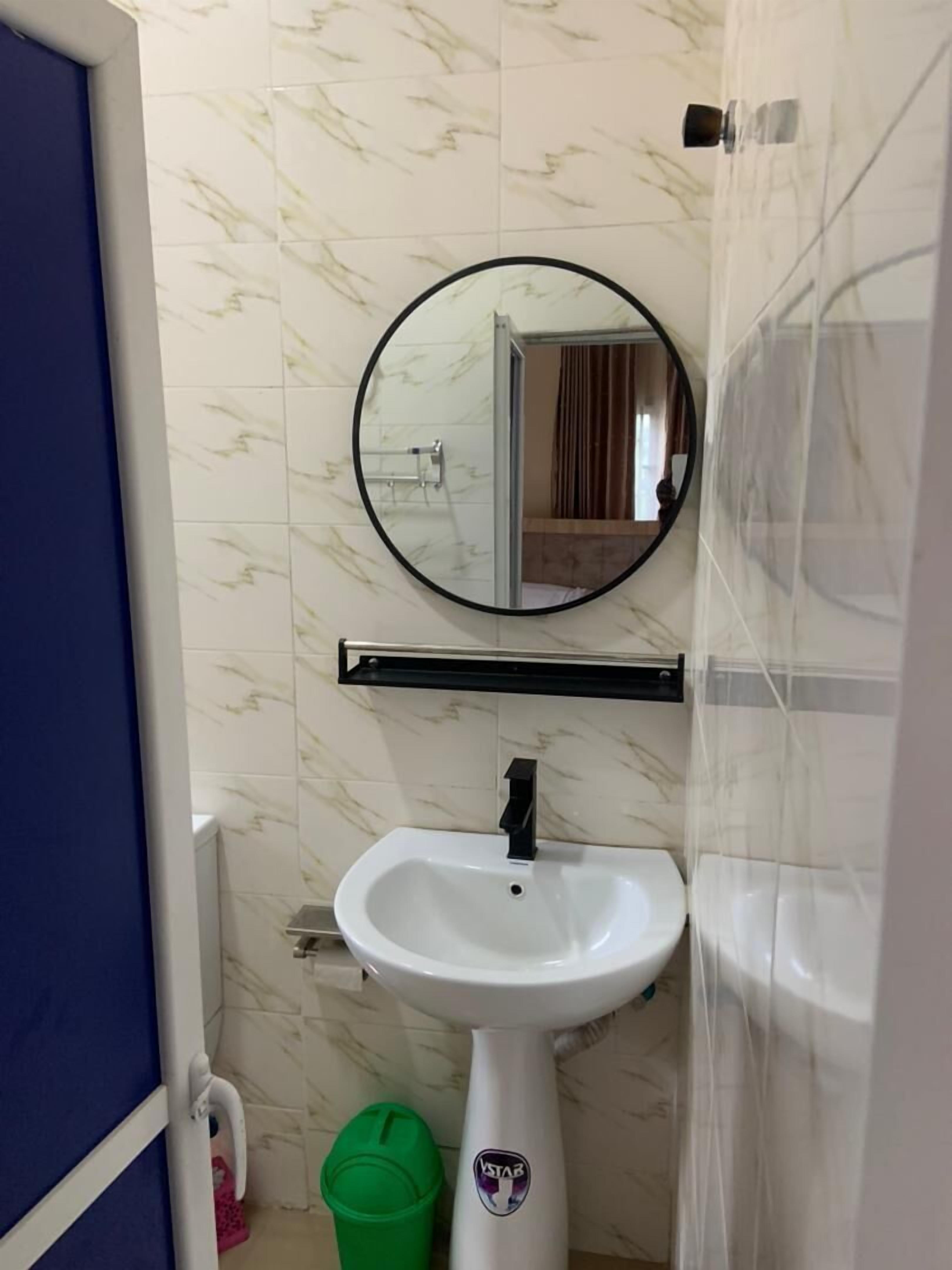 A bathroom with a white sink, a mirror, and a toilet.