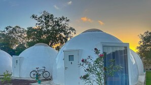 A series of dome-shaped structures with a door and a bicycle parked in front.
