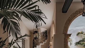 A staircase with a checkered floor, surrounded by potted plants and a hanging lantern.