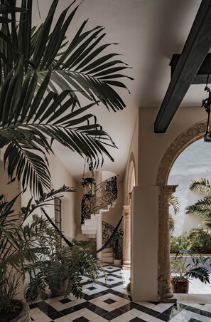 A staircase with a checkered floor, surrounded by potted plants and a hanging lantern. - Casa Japa by Casonas MX (Campeche)