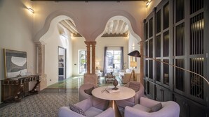 Amplia sala de estar con una mesa de centro redonda, asientos cómodos y un ventanal grande.