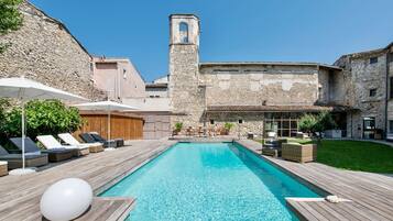 Een seizoensgebonden buitenzwembad en parasols bij het zwembad