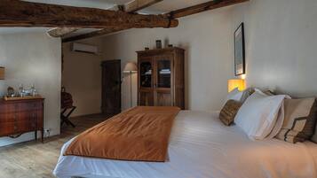 Un dormitorio con una cama grande, un armario de madera y una lámpara.