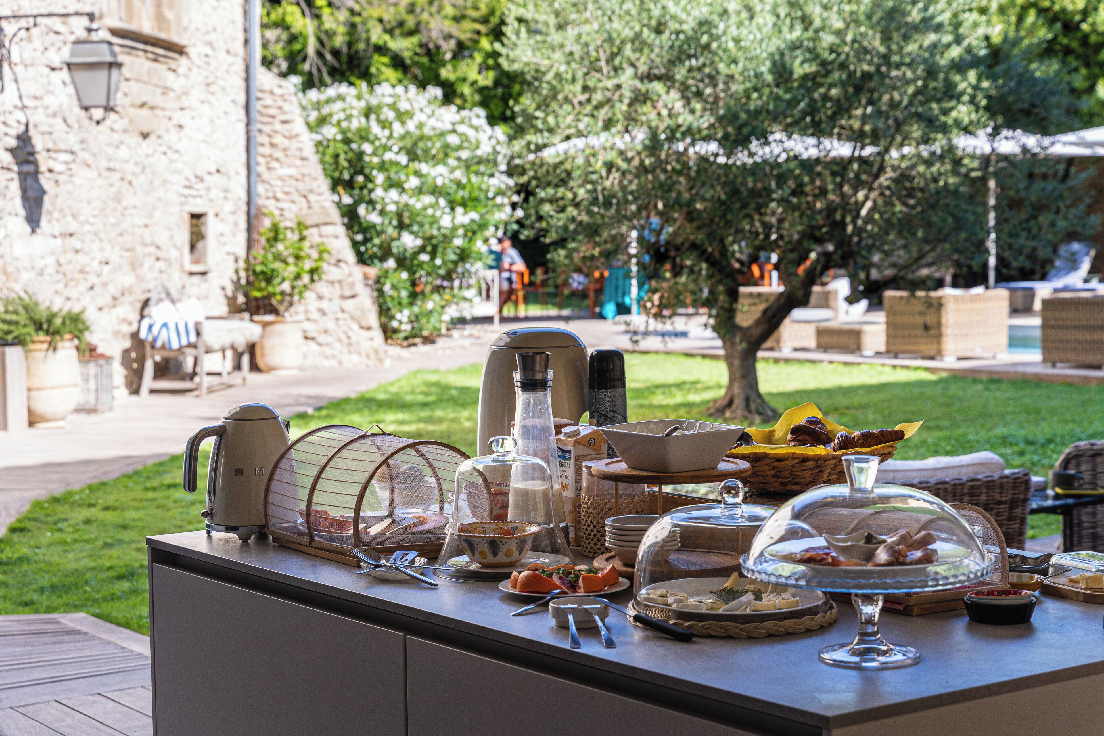 A breakfast buffet with various food items and kitchen appliances on a table.