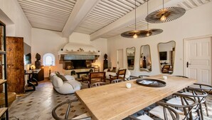 Amplia sala de estar con una gran mesa de madera, asientos cómodos y una chimenea.