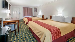 A hotel room with two beds, a desk, a chair, a TV, and a window with curtains. - Hilliard Motor Lodge (Hilliard)