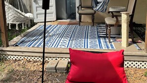 A covered patio with a hammock, a chair, and a red cushion. - Newly Renovated 1936 Home Close To Augusta National, Airport & Downtown! (Augusta)