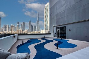A rooftop terrace with a city skyline view, including a prominent skyscraper. - Elegant 2BR Suite Near Downtown Dubai (Dubai)