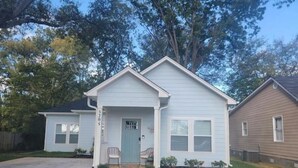 A single-story house with a front porch, a mailbox, and a small front yard. - The Sugar Shack Cottage with Hot Tub (Tupelo)