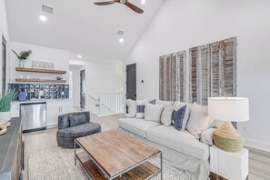 Relax in this stylish living space with a high ceiling, sofa, and coffee table.