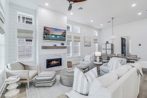 Relax in a spacious living room with a comfortable sofa, armchairs, and a fireplace.