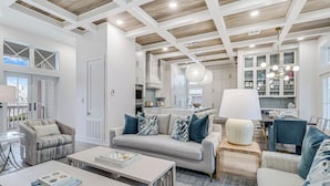 Una cocina moderna con armarios blancos, una isla central y un colgador de luces.