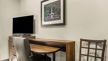 A modern office space with a desk, chair, and a framed picture of a fountain.
