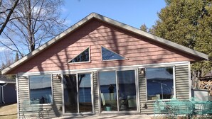 A single-story house with large windows and a covered patio area. -  House Lakefront Beautiful Sleeps 12 AC, Wi Fi, 38 minutes to GB (Shawano)