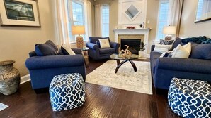 A spacious living room with two sofas, a coffee table, and patterned ottomans. - 4-bedroom vacation home steps to Seaside Heights Boardwalk (Seaside Heights)