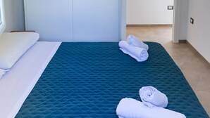 Ett hotellrum med en säng, en lampa och två tavlor på väggen.