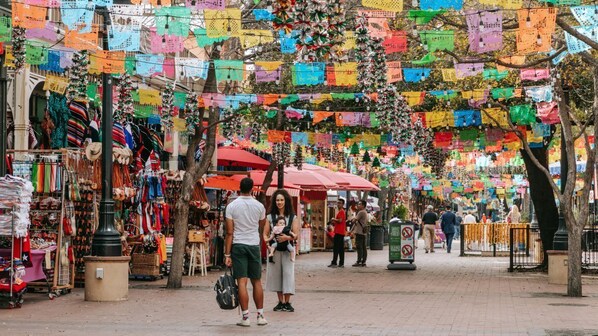 Un mercado al aire libre animado con puestos coloridos y una gran variedad de productos.