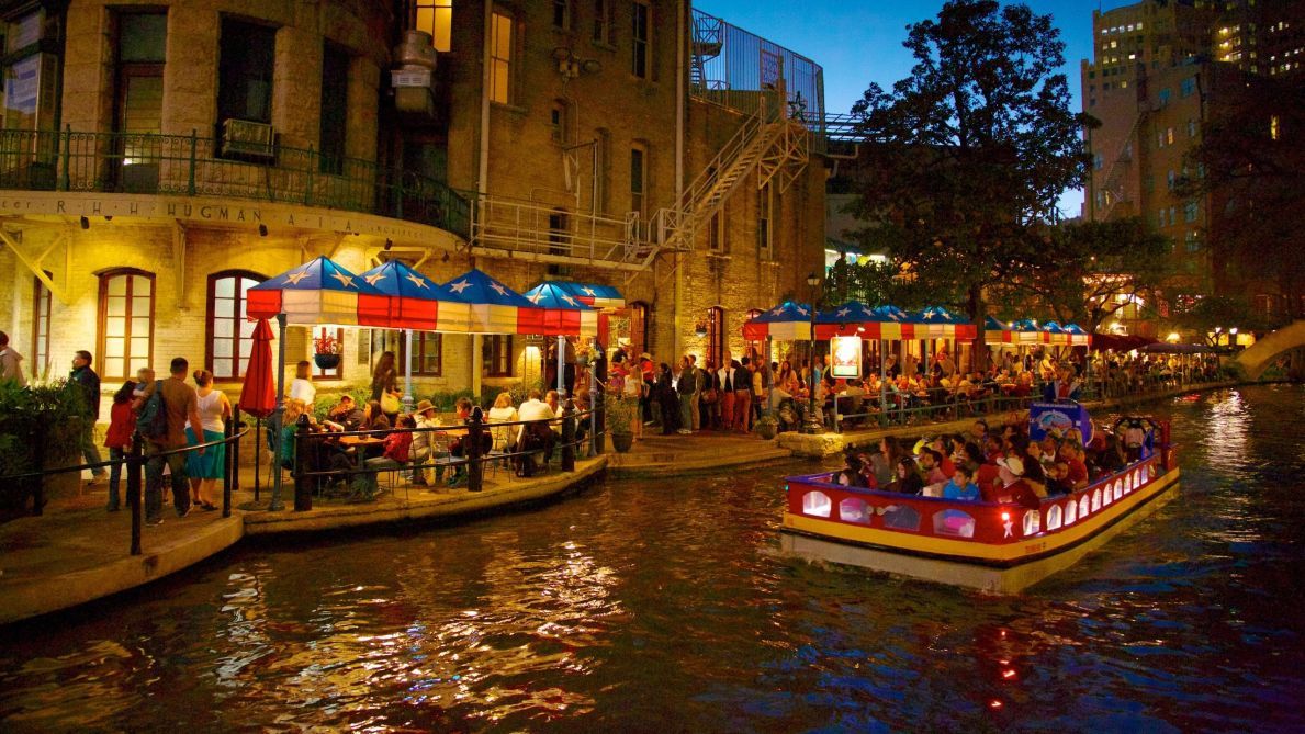 A riverside area with boats and outdoor seating areas.
