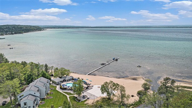 A coastal property with a swimming pool, beach, and pier extending into the water. - 2 Bedroom Condo Golf Course Views 5166 (Williamsburg)