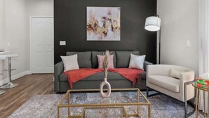 A modern living room with a grey sofa, a white armchair, a coffee table, and a floor lamp. - Stylish 2BR Scottsdale, Pet-friendly, Sunrise Peak (Scottsdale)