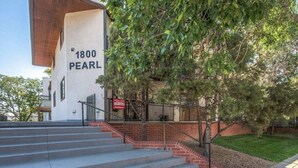 Un edificio con un letrero que dice "1800 PEARL" y un cartel rojo de "En venta".